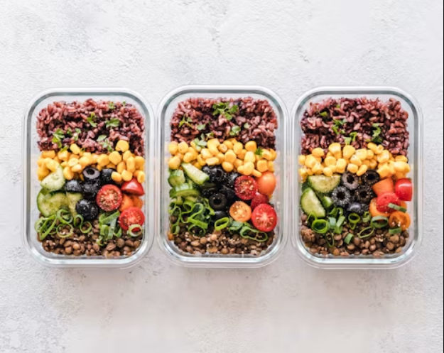 Vegan meal prep ideas shown in glass containers with rice, beans, and roasted vegetables